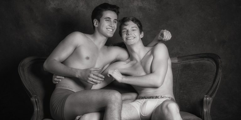 Gay couples boudoir photography Houston — playful black and white session on settee by Trey Fox